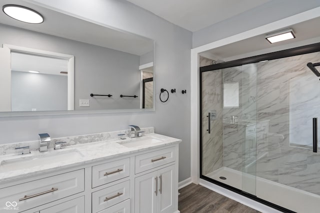 3735 Marrison Pl, Indianapolis, IN 46205 - full bath with double vanity, a marble finish shower, wood finished floors, and baseboards
