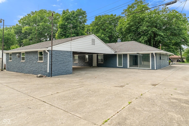 3735 Marrison Pl, Indianapolis, IN 46205 - ranch-style home featuring driveway, stone siding, a carport, a chimney, and roof with shingles