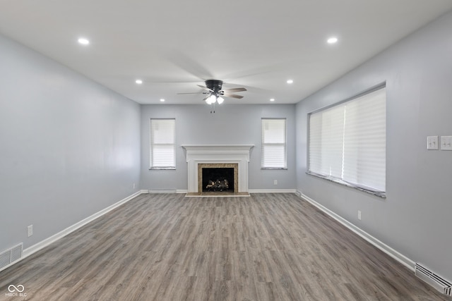 3735 Marrison Pl, Indianapolis, IN 46205 - unfurnished living room featuring a ceiling fan, wood finished floors, baseboards, a fireplace with raised hearth, and recessed lighting