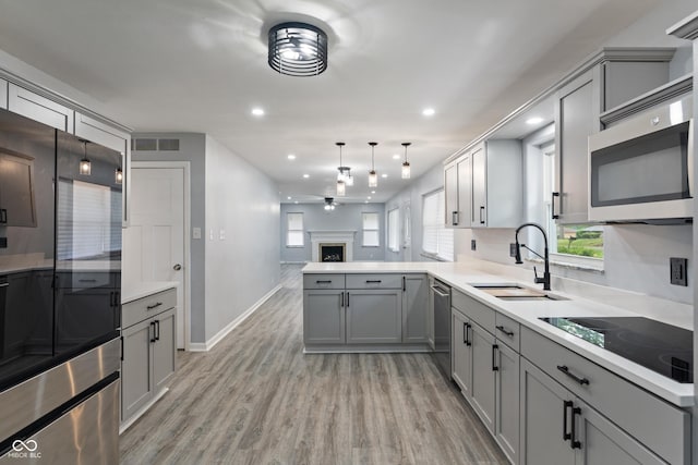 3735 Marrison Pl, Indianapolis, IN 46205 - kitchen with gray cabinets, stainless steel appliances, a sink, ceiling fan, and light wood-type flooring