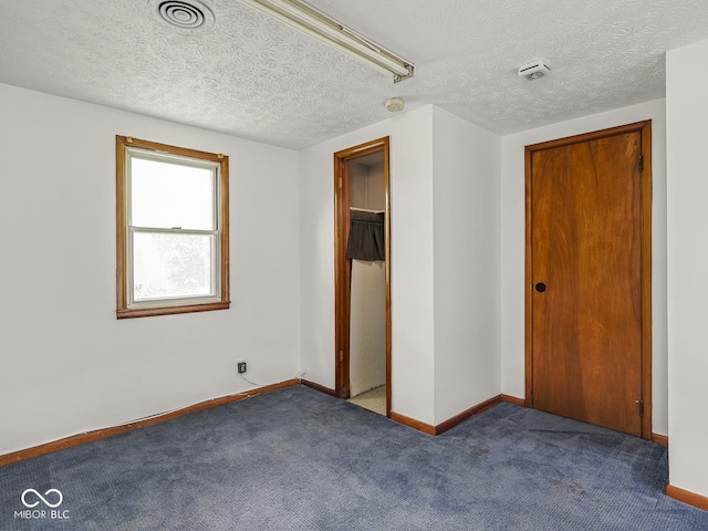 4305 Clinton St, Lawrence, IN 46226 - unfurnished bedroom featuring a closet, carpet, a textured ceiling, and baseboards