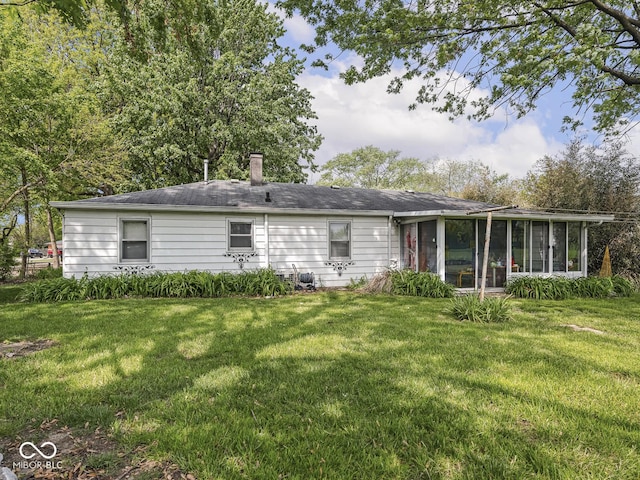 4305 Clinton St, Lawrence, IN 46226 - rear view of property with a sunroom, a lawn, and a chimney