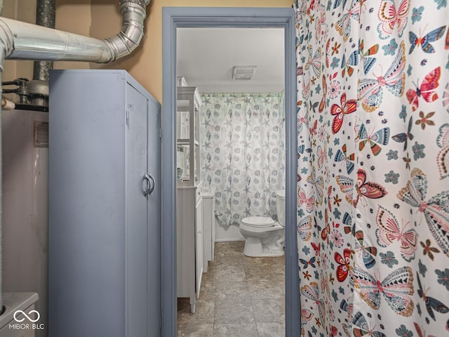 4305 Clinton St, Lawrence, IN 46226 - bathroom with toilet, stone finish floors, water heater, and a shower with shower curtain