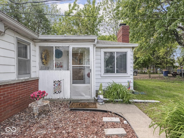4305 Clinton St, Lawrence, IN 46226 - view of exterior entry featuring a chimney and a lawn