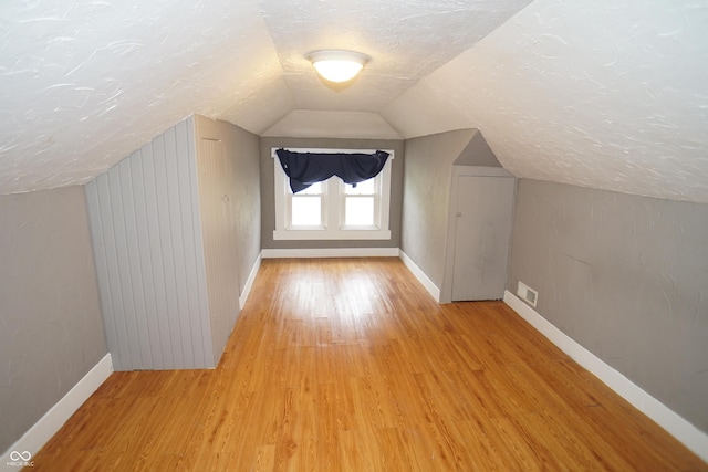 524 Hoene Ave, Batesville, IN 47006 - bonus room featuring a textured ceiling, baseboards, light wood-style flooring, and vaulted ceiling