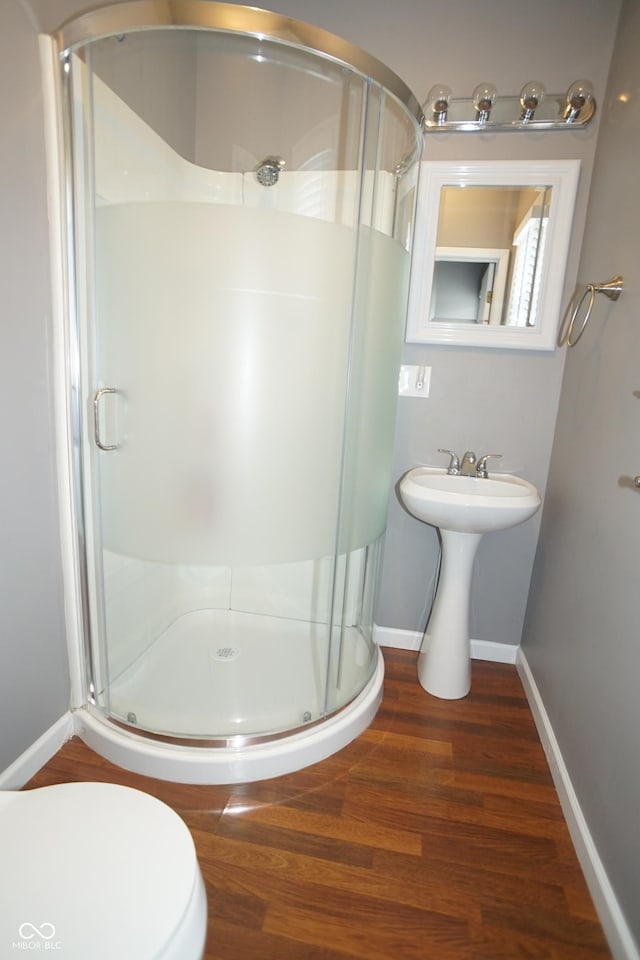 524 Hoene Ave, Batesville, IN 47006 - bathroom featuring a stall shower, wood finished floors, baseboards, and toilet