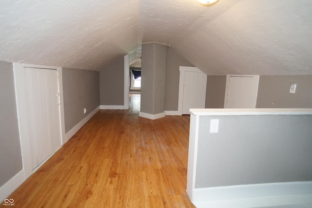 524 Hoene Ave, Batesville, IN 47006 - bonus room featuring a textured ceiling, light wood-style flooring, vaulted ceiling, and baseboards