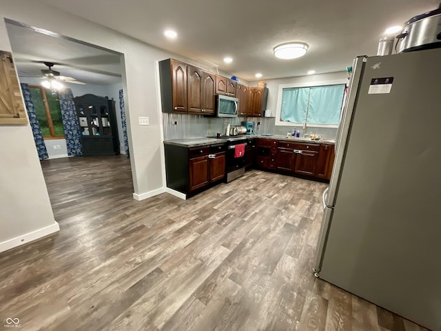 6593 N 800 W, Elwood, IN 46036 - kitchen featuring appliances with stainless steel finishes, wood finished floors, light countertops, ceiling fan, and backsplash