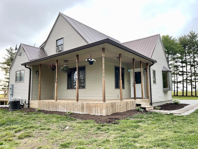 6593 N 800 W, Elwood, IN 46036 - view of home's exterior featuring a porch, a lawn, metal roof, and central air condition unit