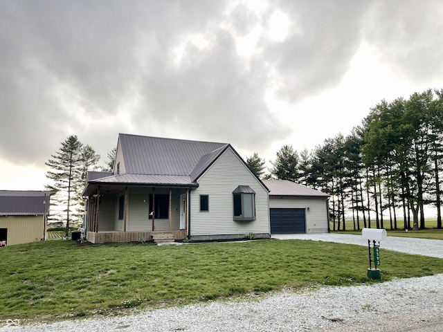 6593 N 800 W, Elwood, IN 46036 - view of front of house with a porch, gravel driveway, a front lawn, an attached garage, and metal roof