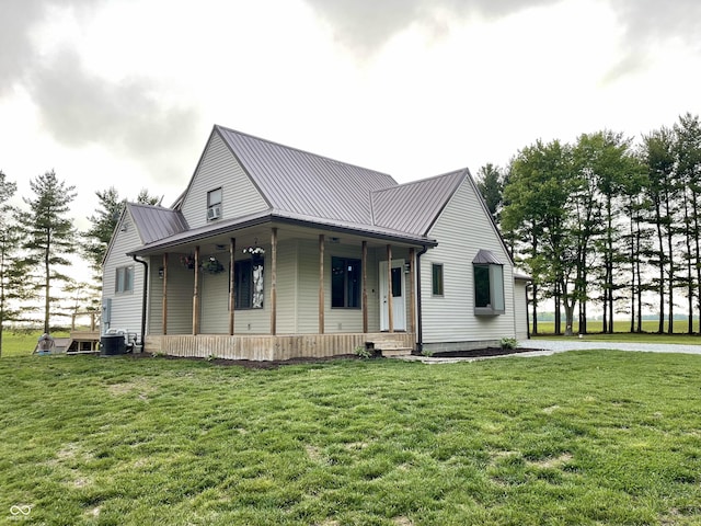 6593 N 800 W, Elwood, IN 46036 - view of front of home with a porch, cooling unit, a front yard, metal roof, and a standing seam roof