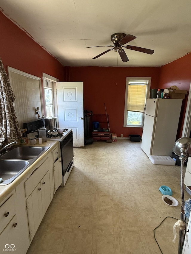 2310 Noble St, Anderson, IN 46016 - kitchen featuring white appliances, a sink, white cabinets, and plenty of natural light
