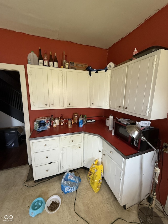 2310 Noble St, Anderson, IN 46016 - kitchen featuring white cabinets, dark countertops, and light flooring