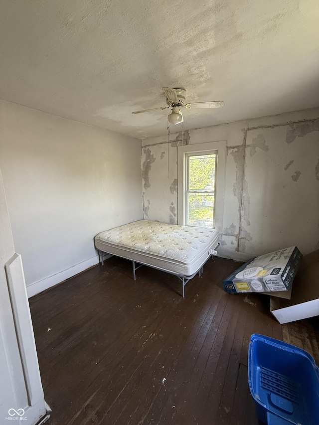 2310 Noble St, Anderson, IN 46016 - unfurnished bedroom with hardwood / wood-style flooring, a textured ceiling, a ceiling fan, and baseboards