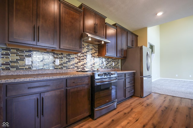 9018 E Gayle Dr, Morgantown, IN 46160 - kitchen featuring under cabinet range hood, stove, dark brown cabinetry, light wood-style flooring, and freestanding refrigerator