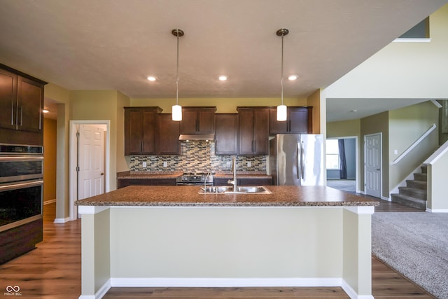 9018 E Gayle Dr, Morgantown, IN 46160 - kitchen featuring appliances with stainless steel finishes, dark brown cabinets, wood finished floors, backsplash, and a kitchen island with sink