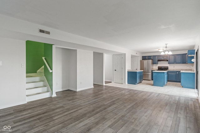 1408 Snead Cir, Avon, IN 46123 - unfurnished living room with a chandelier, light wood-style floors, and baseboards