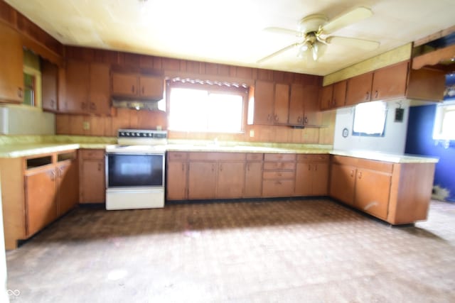 10577 Dalton Rd, Hagerstown, IN 47346 - kitchen with electric stove, under cabinet range hood, light countertops, and dark flooring