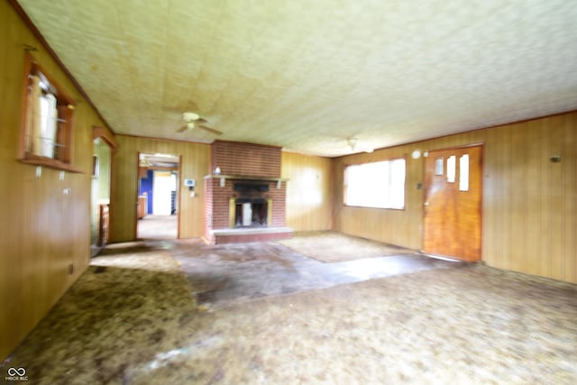 10577 Dalton Rd, Hagerstown, IN 47346 - unfurnished living room with carpet floors, wooden walls, a fireplace, and a ceiling fan