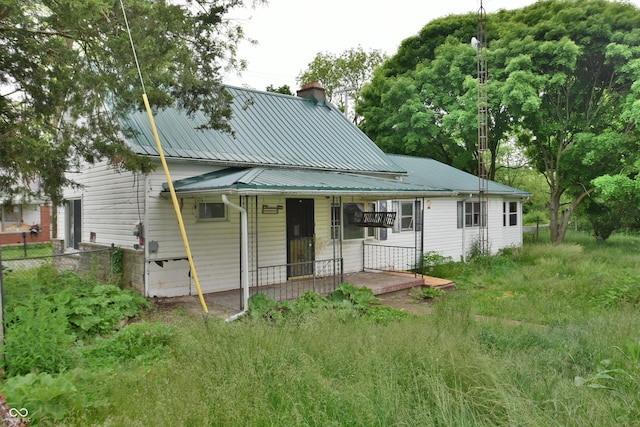 10577 Dalton Rd, Hagerstown, IN 47346 - rear view of house featuring a chimney, covered porch, and metal roof