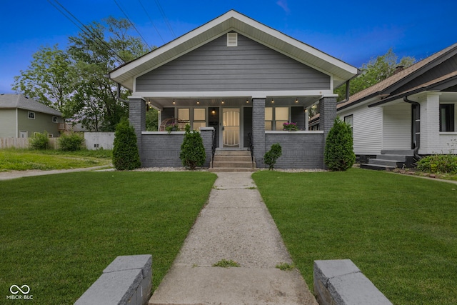441 N Temple Ave, Indianapolis, IN 46201 - view of front of home with a porch, a front lawn, and brick siding