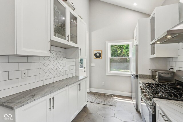 923 42nd St, Indianapolis, IN 46205 - kitchen with stainless steel gas range oven, wall chimney exhaust hood, light stone countertops, white cabinetry, and decorative backsplash