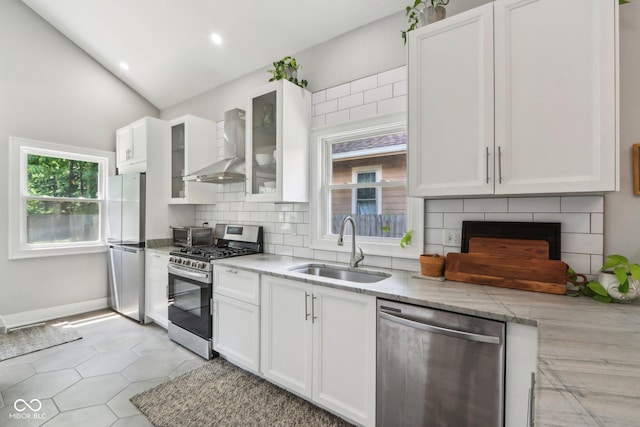 923 42nd St, Indianapolis, IN 46205 - kitchen with stainless steel appliances, wall chimney exhaust hood, white cabinets, tasteful backsplash, and glass insert cabinets