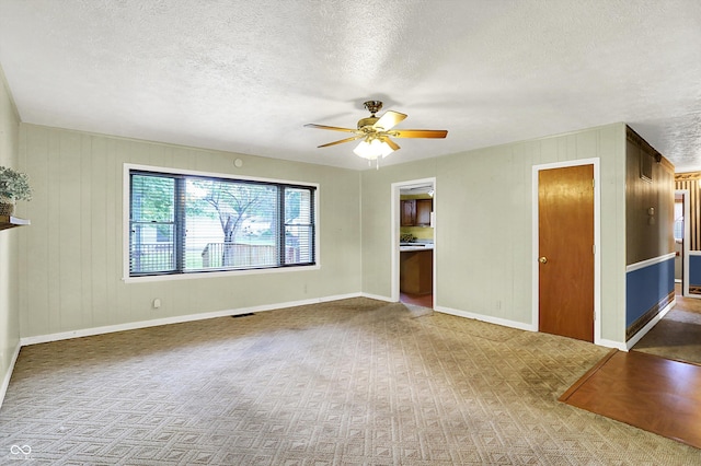 101 Heiny Rd, Indianapolis, IN 46217 - unfurnished living room with a textured ceiling, ceiling fan, baseboards, carpet, and wood walls