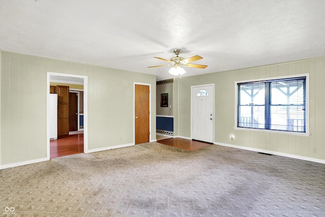 101 Heiny Rd, Indianapolis, IN 46217 - unfurnished living room featuring ceiling fan, carpet floors, baseboards, and a textured ceiling