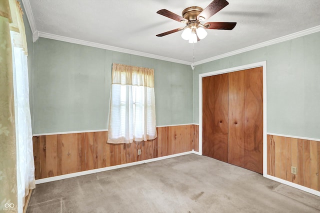 101 Heiny Rd, Indianapolis, IN 46217 - unfurnished bedroom featuring wood walls, ornamental molding, carpet flooring, a closet, and a ceiling fan
