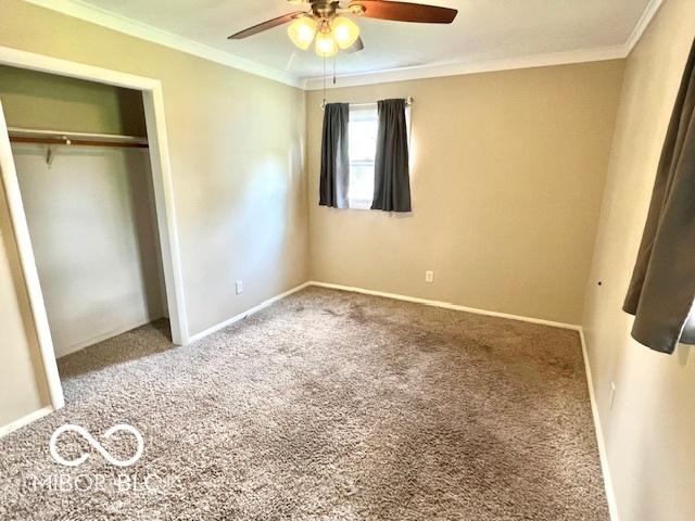 1834 Chandler Ln, Columbus, IN 47203 - unfurnished bedroom featuring carpet flooring, crown molding, a closet, baseboards, and a ceiling fan