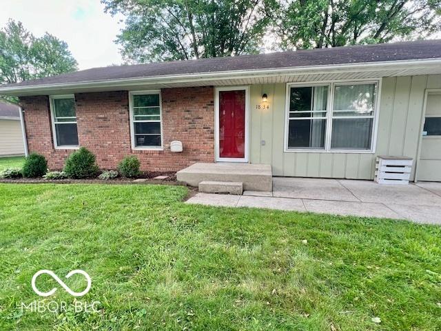 1834 Chandler Ln, Columbus, IN 47203 - ranch-style home with a front lawn, board and batten siding, and brick siding