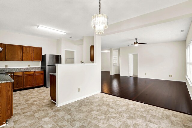 630 Harmony Way, Greenwood, IN 46143 - kitchen with freestanding refrigerator, brown cabinetry, ceiling fan, a chandelier, and baseboards