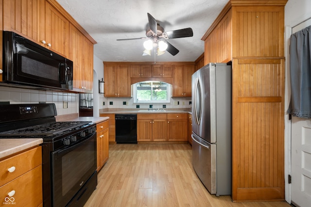 5092 S 50 W, Anderson, IN 46013 - kitchen featuring black appliances, a sink, tasteful backsplash, ceiling fan, and light wood-style flooring