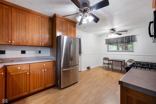 5092 S 50 W, Anderson, IN 46013 - kitchen featuring freestanding refrigerator, brown cabinets, ceiling fan, and tasteful backsplash