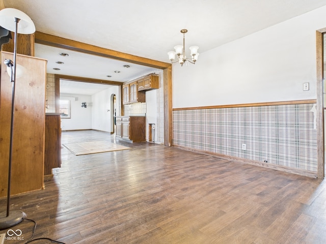 619 Belzer Dr, Anderson, IN 46011 - unfurnished living room with dark wood finished floors, a chandelier, wainscoting, baseboards, and beam ceiling