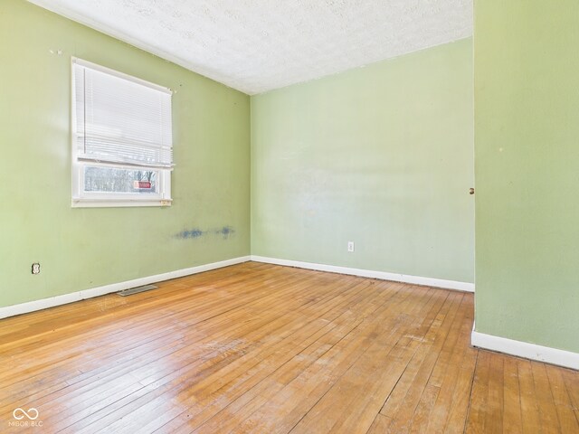 619 Belzer Dr, Anderson, IN 46011 - empty room featuring wood-type flooring, baseboards, and a textured ceiling