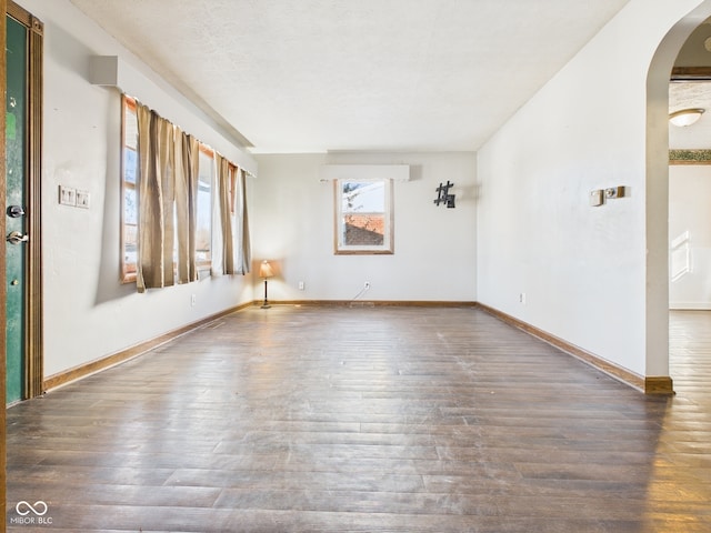 619 Belzer Dr, Anderson, IN 46011 - unfurnished room with arched walkways, wood finished floors, and baseboards