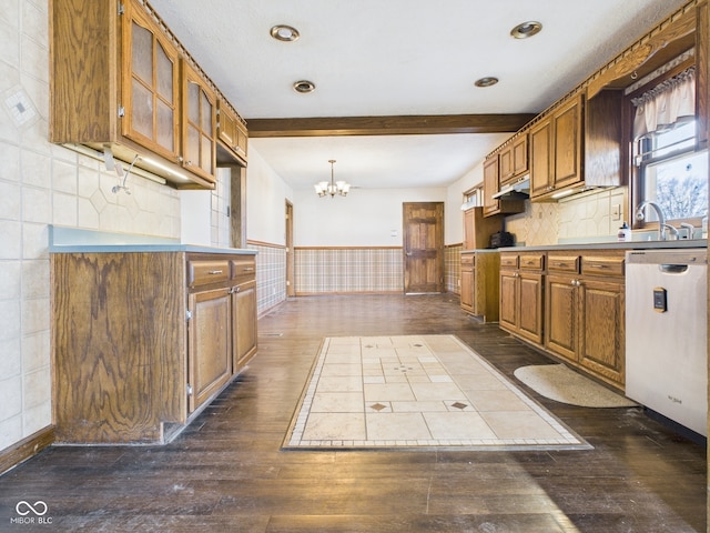 619 Belzer Dr, Anderson, IN 46011 - kitchen featuring dark wood-style floors, a chandelier, dishwasher, brown cabinetry, and under cabinet range hood