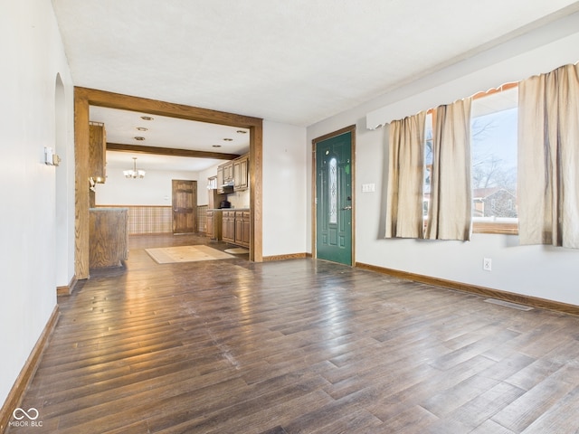 619 Belzer Dr, Anderson, IN 46011 - unfurnished living room with a chandelier, dark wood-type flooring, and baseboards