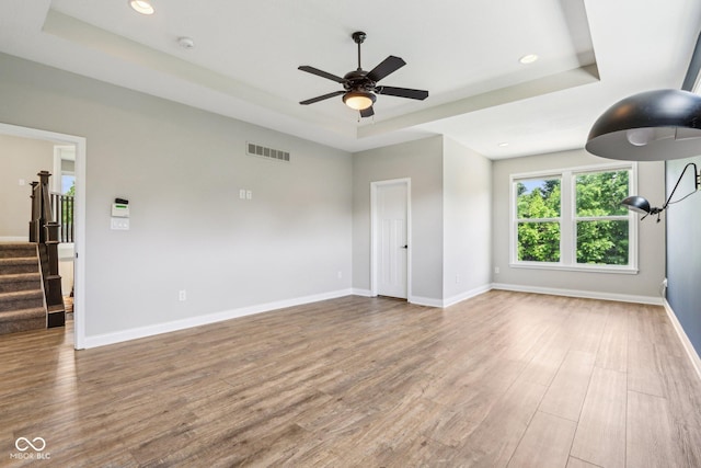 644 Ridge Gate Dr, Brownsburg, IN 46112 - unfurnished room featuring a tray ceiling, wood finished floors, a ceiling fan, stairway, and recessed lighting