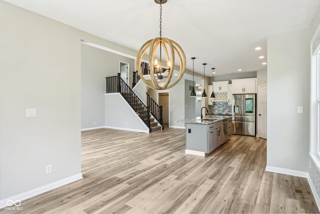 644 Ridge Gate Dr, Brownsburg, IN 46112 - kitchen with stainless steel fridge, a chandelier, tasteful backsplash, light wood-style floors, and recessed lighting