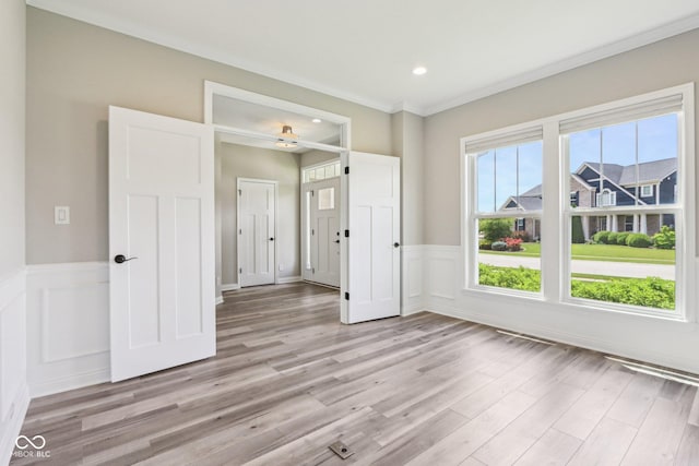 644 Ridge Gate Dr, Brownsburg, IN 46112 - spare room featuring light wood-style floors, wainscoting, recessed lighting, crown molding, and a decorative wall
