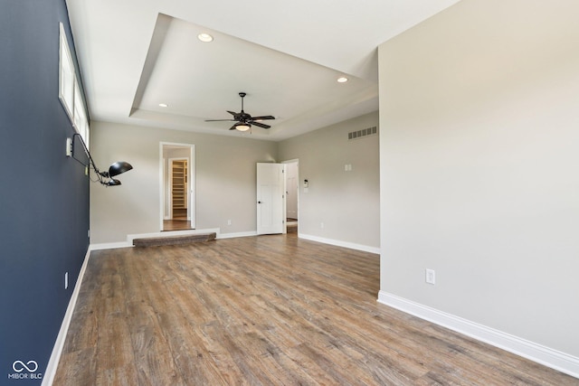 644 Ridge Gate Dr, Brownsburg, IN 46112 - unfurnished living room featuring recessed lighting, baseboards, a ceiling fan, wood finished floors, and a tray ceiling