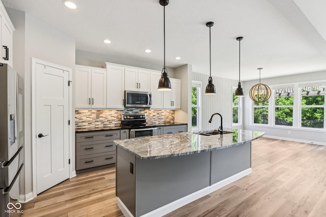 644 Ridge Gate Dr, Brownsburg, IN 46112 - kitchen featuring stainless steel appliances, a sink, light wood finished floors, plenty of natural light, and recessed lighting