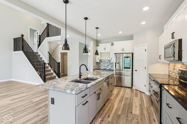 644 Ridge Gate Dr, Brownsburg, IN 46112 - kitchen featuring stainless steel appliances, a sink, light wood-style floors, backsplash, and recessed lighting