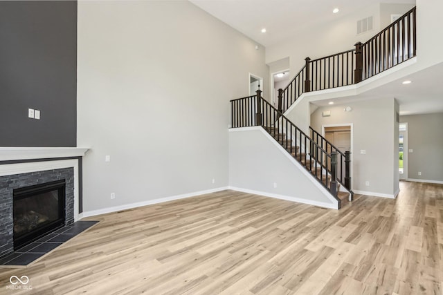 644 Ridge Gate Dr, Brownsburg, IN 46112 - unfurnished living room with a towering ceiling, wood finished floors, stairway, baseboards, and recessed lighting