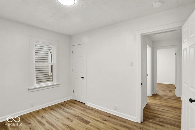2015 S Hackley St, Muncie, IN 47302 - empty room featuring light wood-type flooring, baseboards, a smoke detector, and a textured ceiling