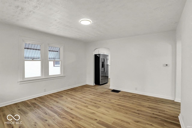 2015 S Hackley St, Muncie, IN 47302 - empty room with light wood finished floors, baseboards, and a textured ceiling