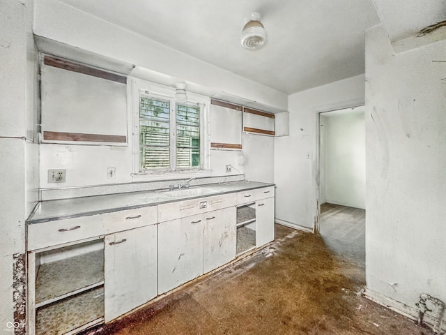 3615 N Dequincy St, Indianapolis, IN 46218 - kitchen with a sink, unfinished concrete floors, open shelves, light countertops, and white cabinetry